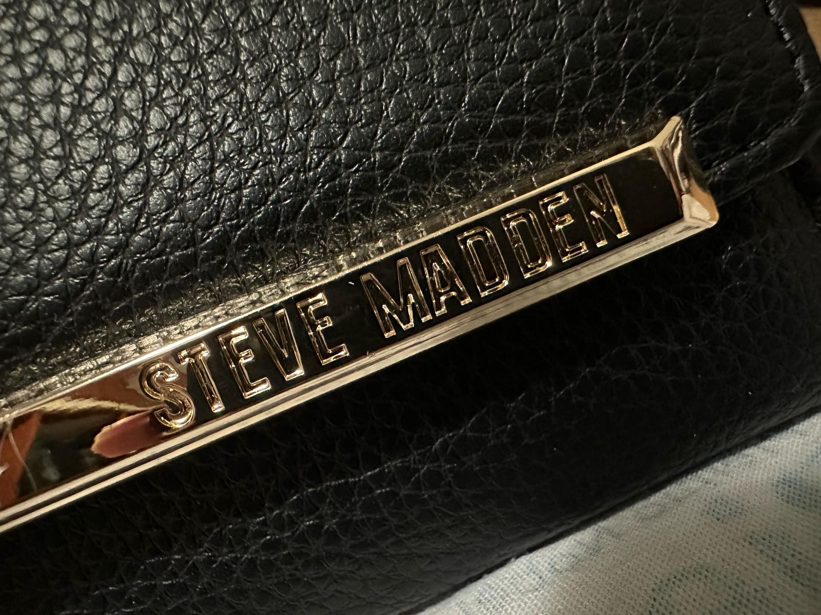 Cartera Steve Madden Negra – Estilo Clutch con Detalle Dorado